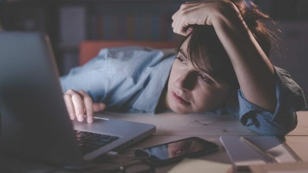 Woman looking exhausted at her desk.