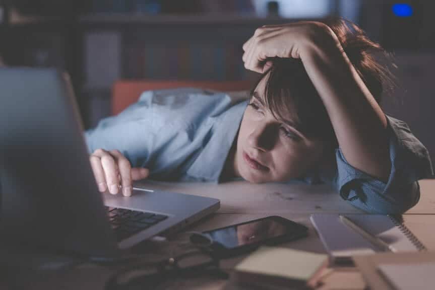 Woman looking exhausted at her desk.