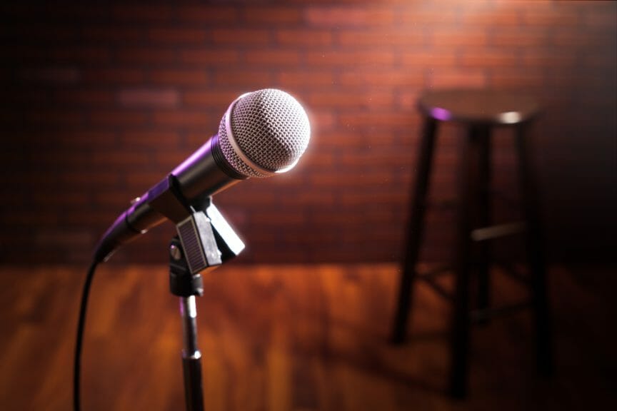 Microphone on a stand up comedy stage with reflectors ray, high contrast image.
