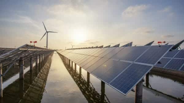 row of climate-friendly energy solar panels and wind turbines. Inflation Reduction Act, Biden,