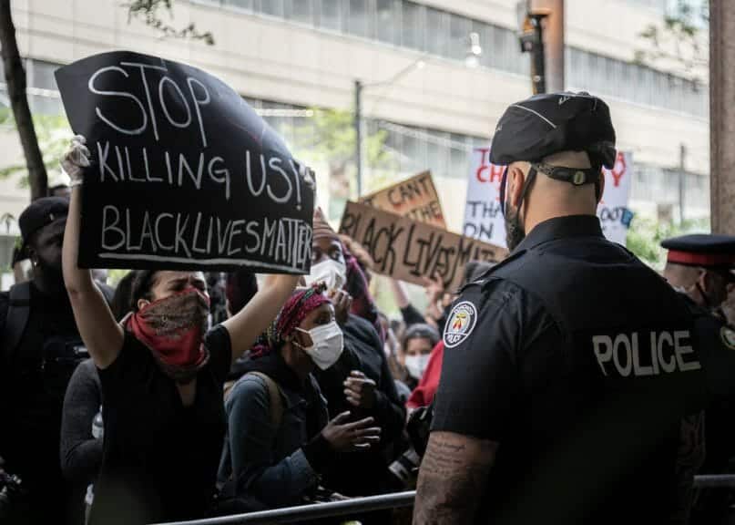 Protest against police brutality. Black lives matter Toronto. Protester confronting a police officer.