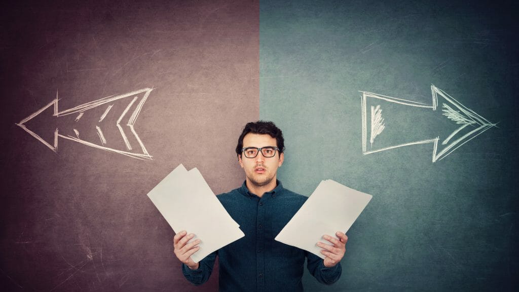 man standing holding papers in his hand with two arrows behind him pointing in different directions.