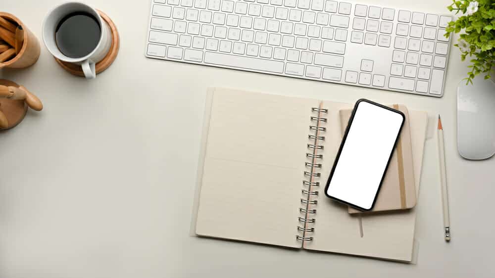 Top view of computer desk with keyboard, smartphone, stationery and coffee cup, clipping path.