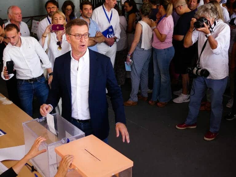 Spain's opposition leader gestures to a ballot box.