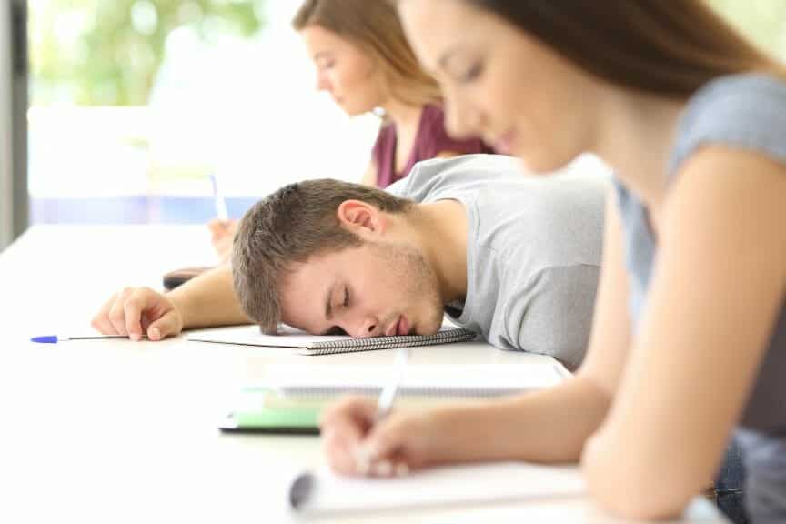 A college student sleeping in their evening class.