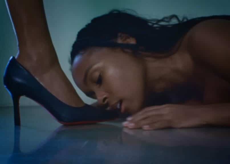 Janelle Monaé kissing a woman’s shoe.