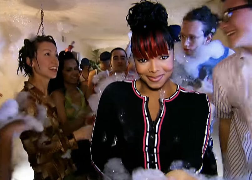 Janet Jackson standing in the middle of a party.