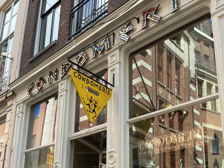 A yellow sign above a shop door in Amsterdam.