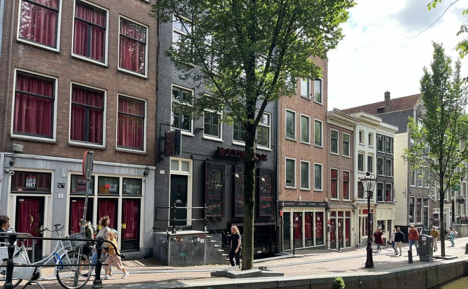 A street in the Red Light District during the morning. The red curtains are drawn in all the windows.