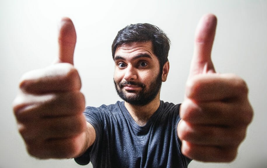 Man holding both of his thumbs up