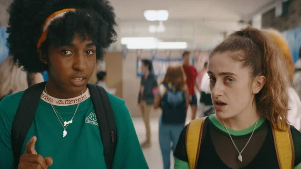 Still from 'Bottoms' in which the two lead actresses stare forward with concerned faces.