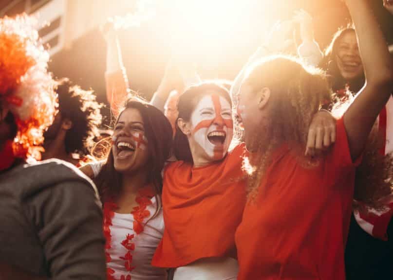 Soccer fans with face paint supporting at a game.