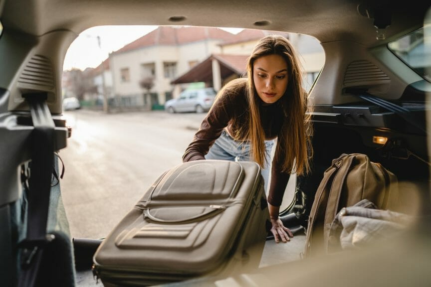Packing up a car with suitcases.