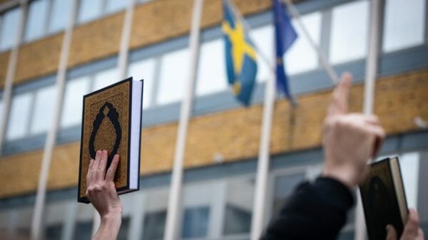 The Quran held in the air outside the Swedish Embassy.
