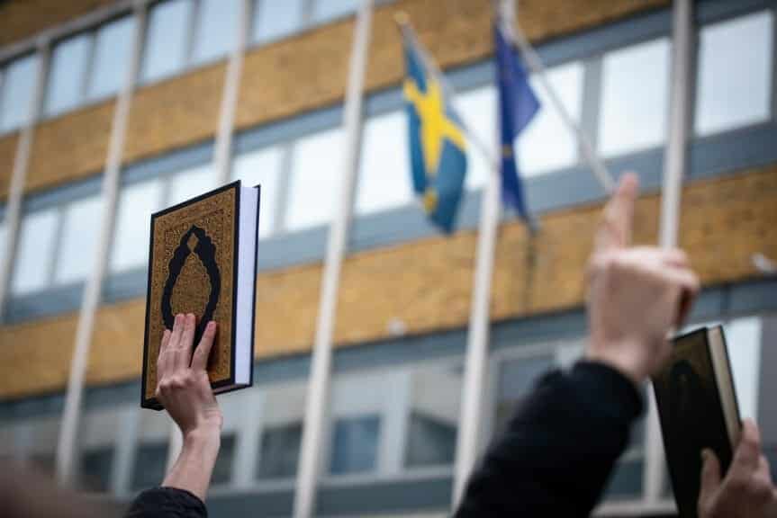 The Quran held in the air outside the Swedish Embassy.