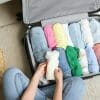 Woman packing up suitcase full of clothes