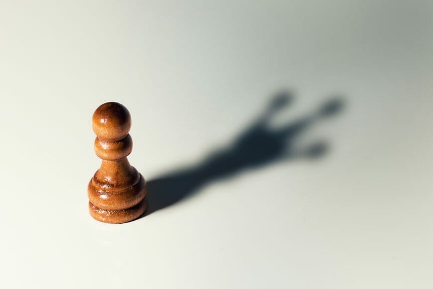 A pawn chess piece but its shadow is the queen.