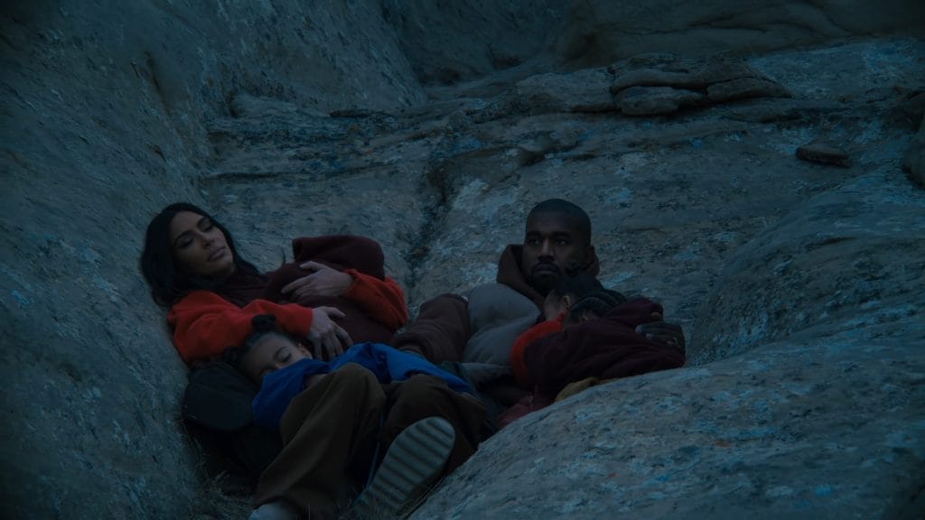 Kanye West, Kim Kardashian, and their children lying down.