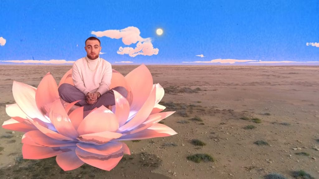 Mac Miller sitting in a giant water lily.