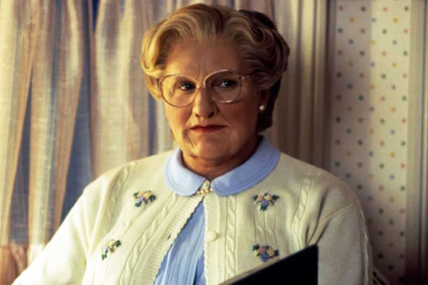 Robin Williams opening a book as Mrs Doubtfire.