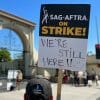 SAG-AFTRA sign saying "We're still here."