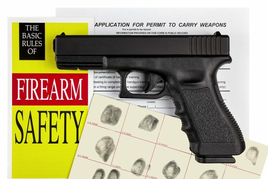Photo of Gun next to Gun Safety manual. Biden