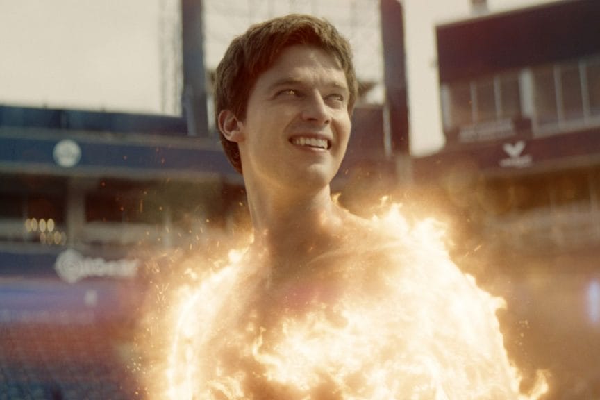 Luke Riordan, aka 'Golden Boy' is seen using his powers of burning up in the first episode. Looking off to the right of the screen, he is smiling as he shows off.