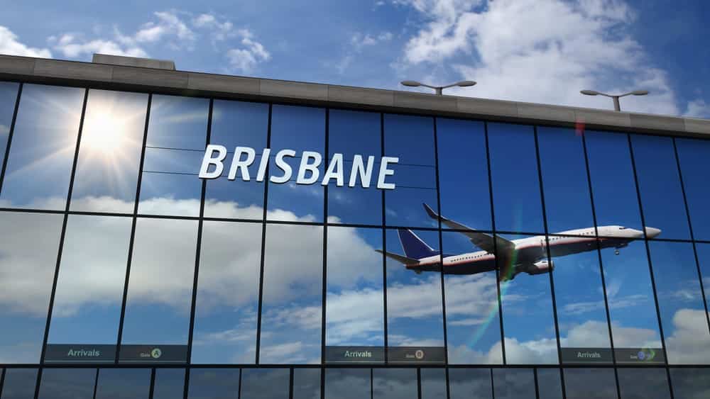 airplane flying out of the brisbane airport in Australia. the word brisbane can be seen on the window.