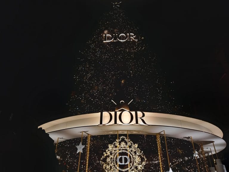 A Christmas tree with the Dior logo at the bottom of it.