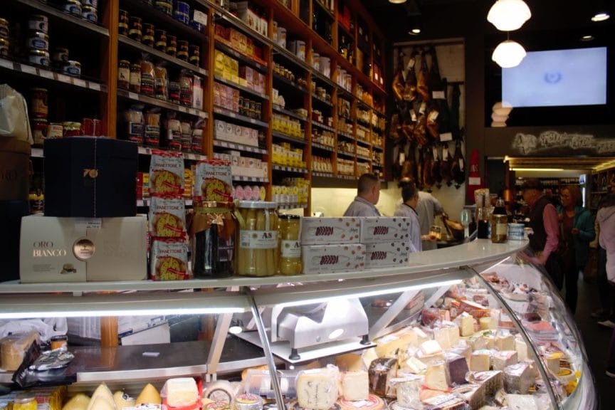 The shop assistsnats at Quilez dealing with customers from behind the glass fridge.