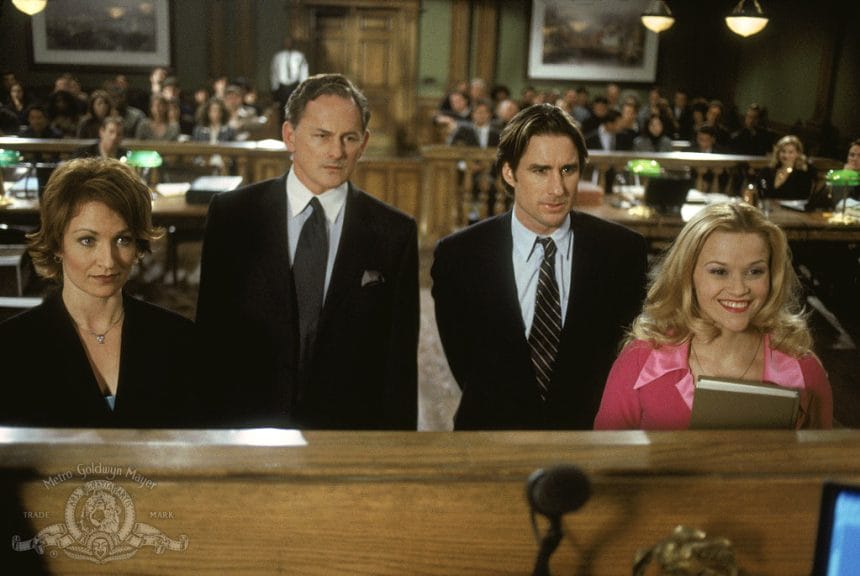 Four characters from Legally Blonde, main character Elle Woods stands out in a pink courtroom outfit. 