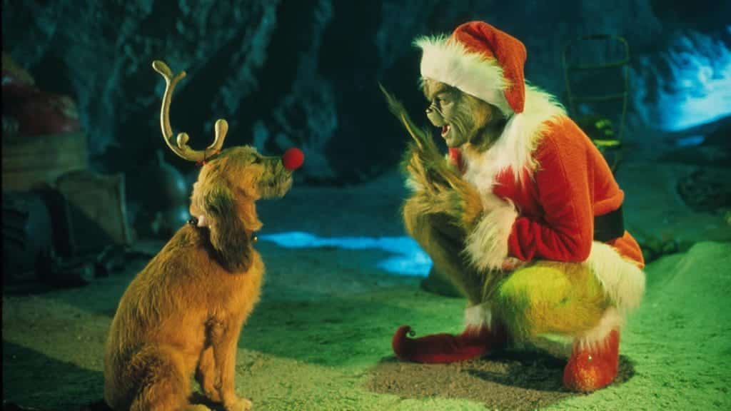 Green goblin pointing and speaking to a dog while crouched.