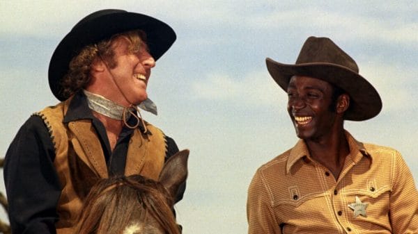 Cleavon Little and Gene Wilder laugh together in a scene from 'Blazing Saddles"