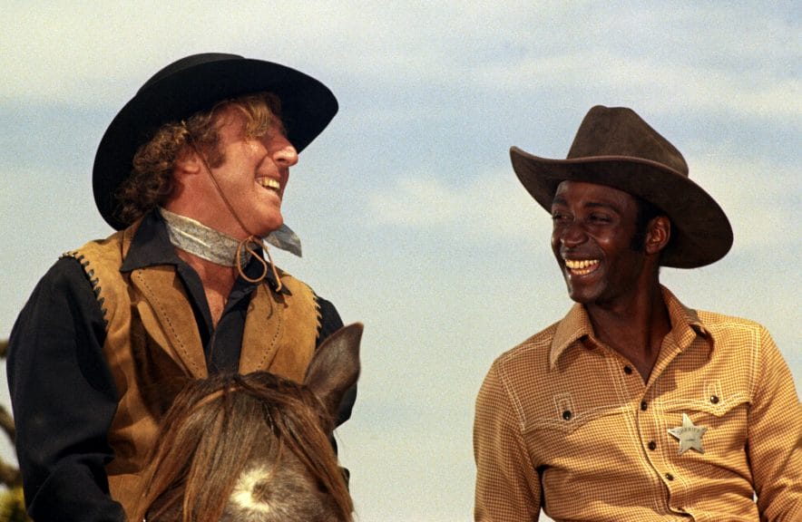 Cleavon Little and Gene Wilder laugh together in a scene from 'Blazing Saddles"