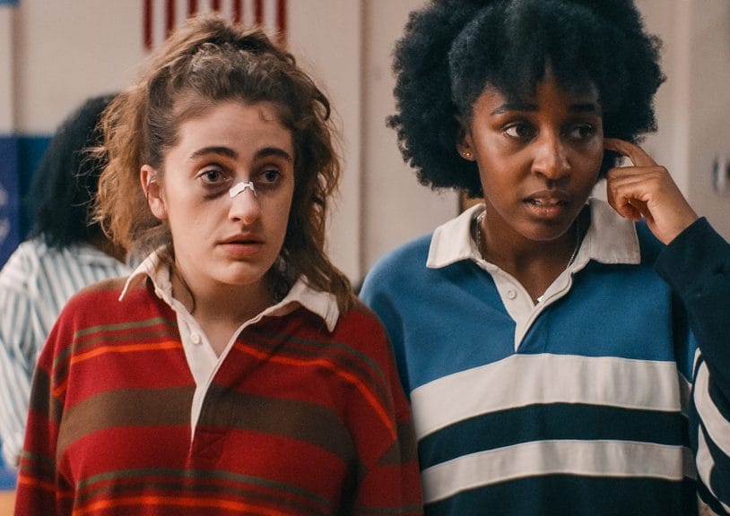 Rachel Sennott and Ayo Edbiri as their characters PJ and Josie from Bottoms both look stunned while covered in bruises. 