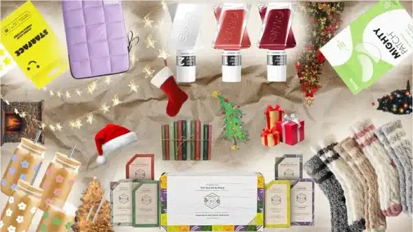 Christmas items like a Santa hat, Christmas trees, presents, and lights are surrounding miscellaneous items: nail polish, soap bars, glass coffee cups, socks, pimple and eye patches, and a laptop case.