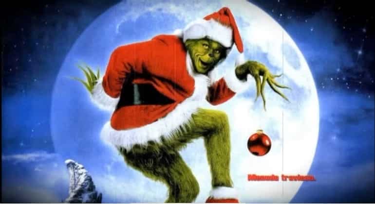 Green monster wearing a Santa garment in front of a full moon.