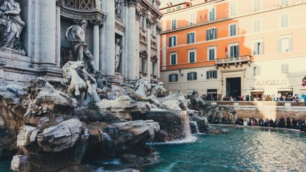 The Trevi fountain with tourists tossing coins