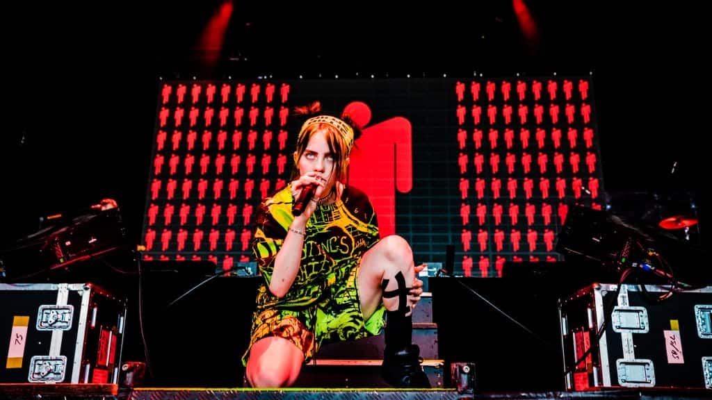 Singer-songwriter Billie Eilish dons her signature green garb as she performs on stage.