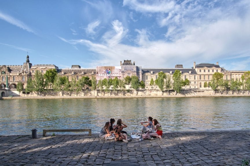 A group of women having a picnic on the Seine River in Paris. 