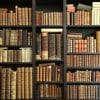 Dark bookshelf with old, bound books.