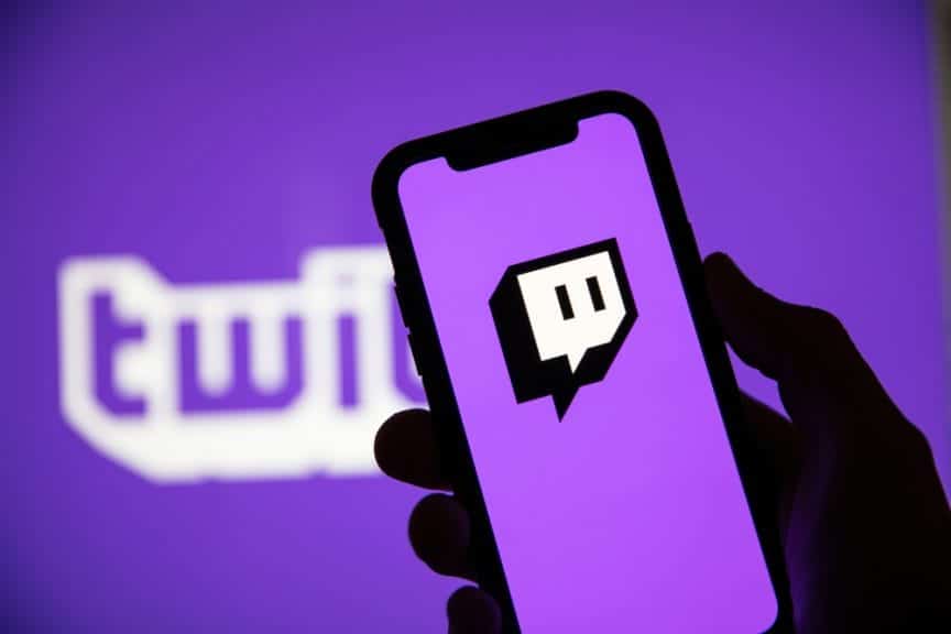 Twitch written in purple and white words with a phone held up showing the Twitch app logo.