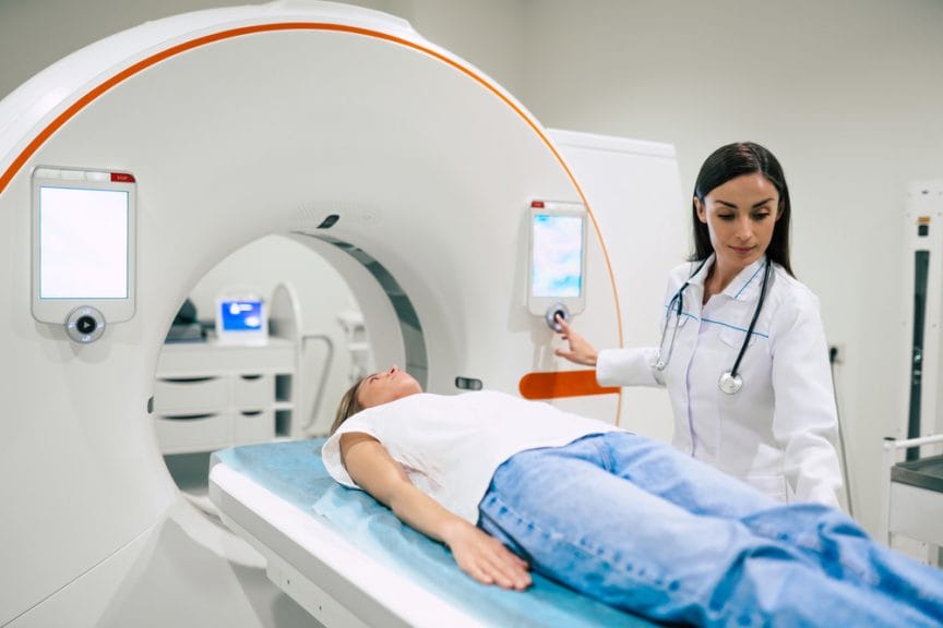 A doctor inserting their patient inside an MRI machine