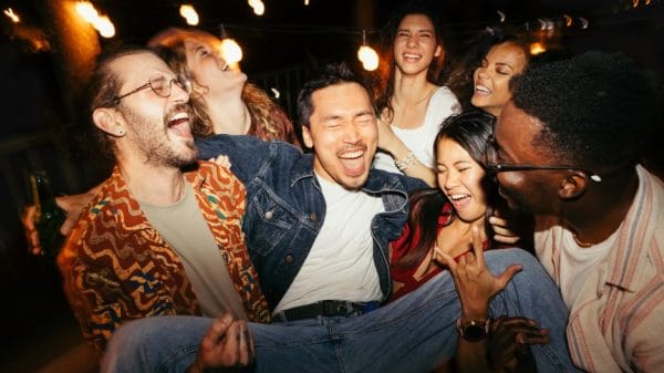 Group of Under 25s drinking in a large group at a bar.