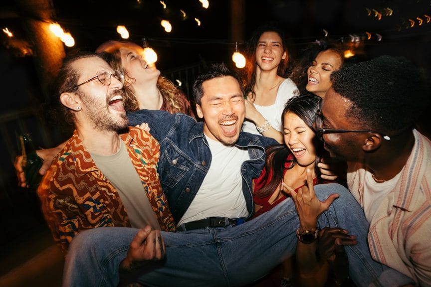 Group of Under 25s drinking in a large group at a bar.