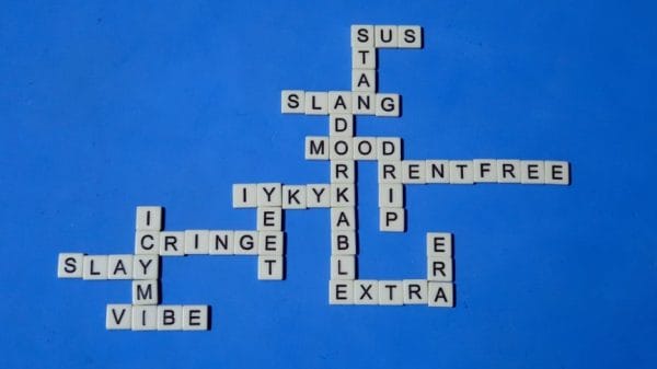 Scrabble board with slang terms such as vibe, extra, etc. Has a blue background