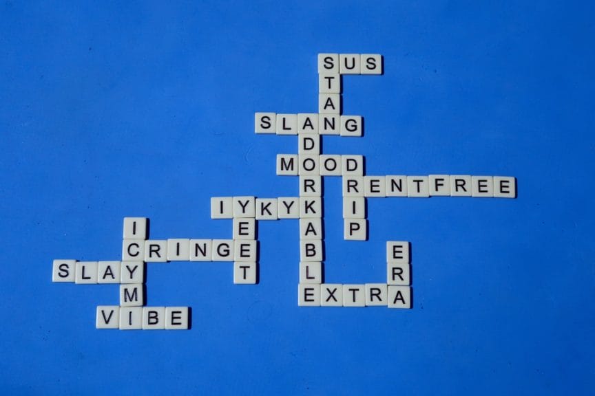 Scrabble board with slang terms such as vibe, extra, etc. Has a blue background