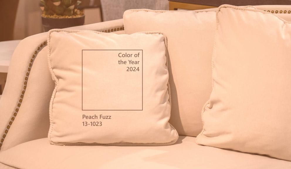 Close-up of a light fabric sofa with warm, cozy cushions in the Pantone Color of the Year 2024, Peach Fuzz.