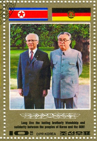 Kim Jong-il standing next to a man
