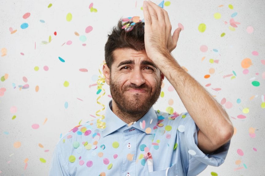 Man looking with regretful look into camera, keeping his hand on forehead.